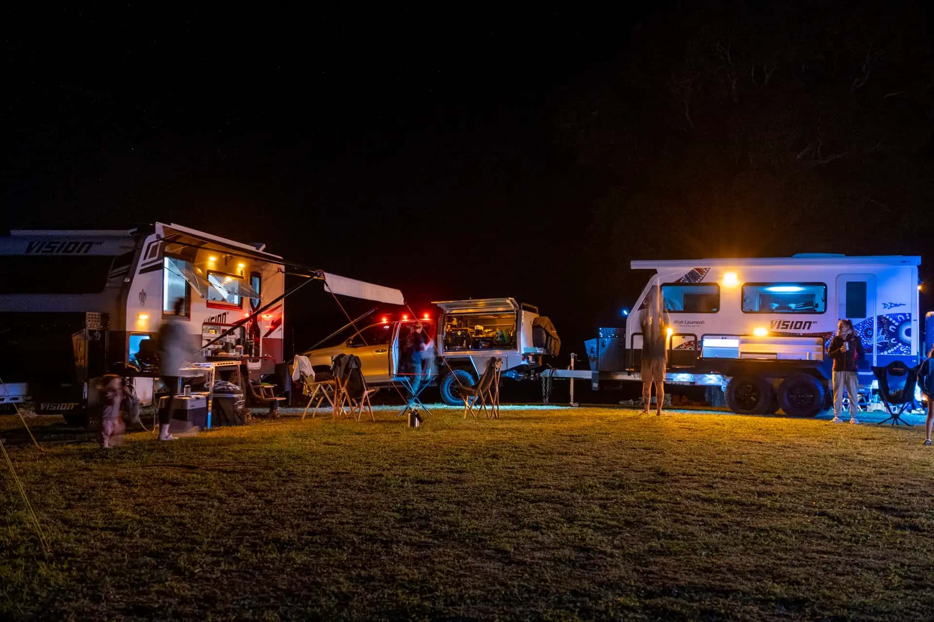 Elysium and Nirvana vans corralled at night camp